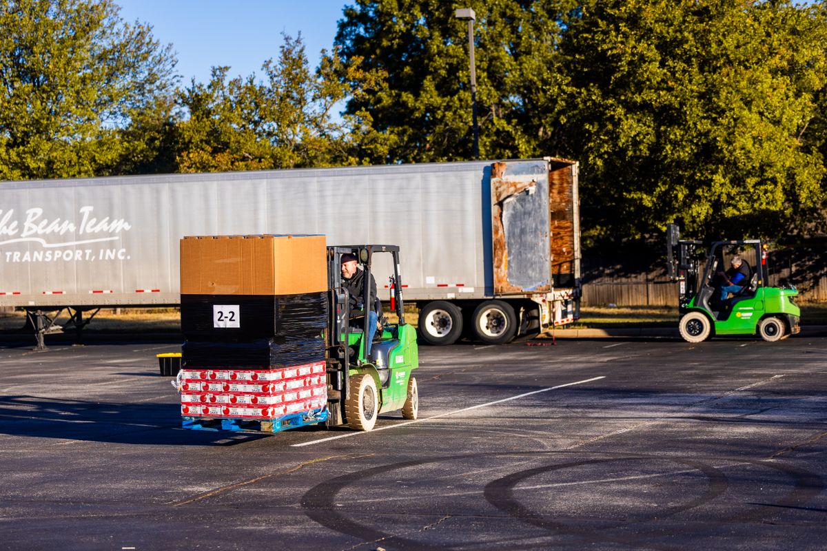 Forklift operators loading pallets onto a truck